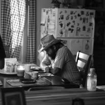 Black-and-white still at a kitchen table